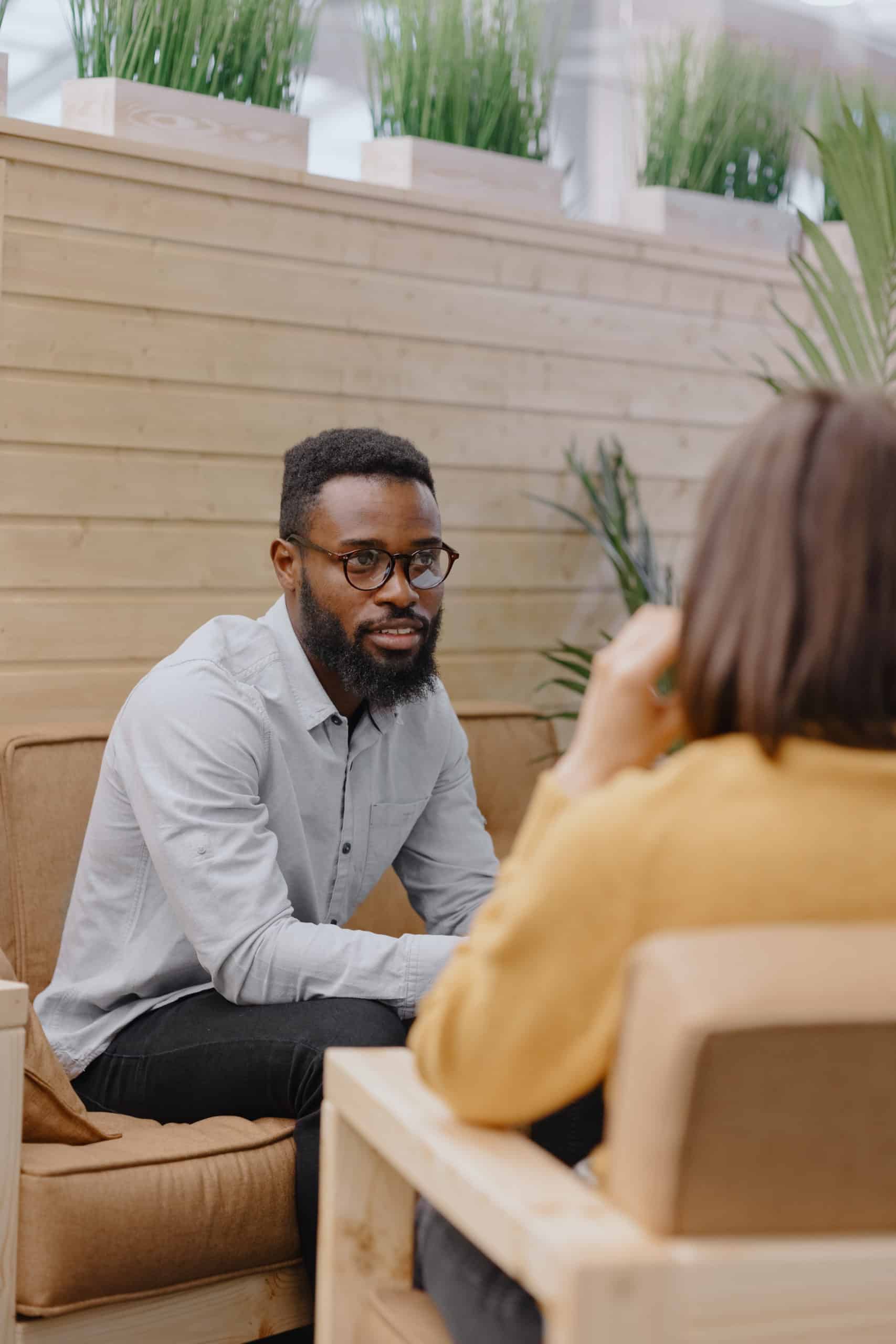 male psychologist conducts a patient's appointment in an office or a medical center. African American male HR conducts an interview of hiring a European woman