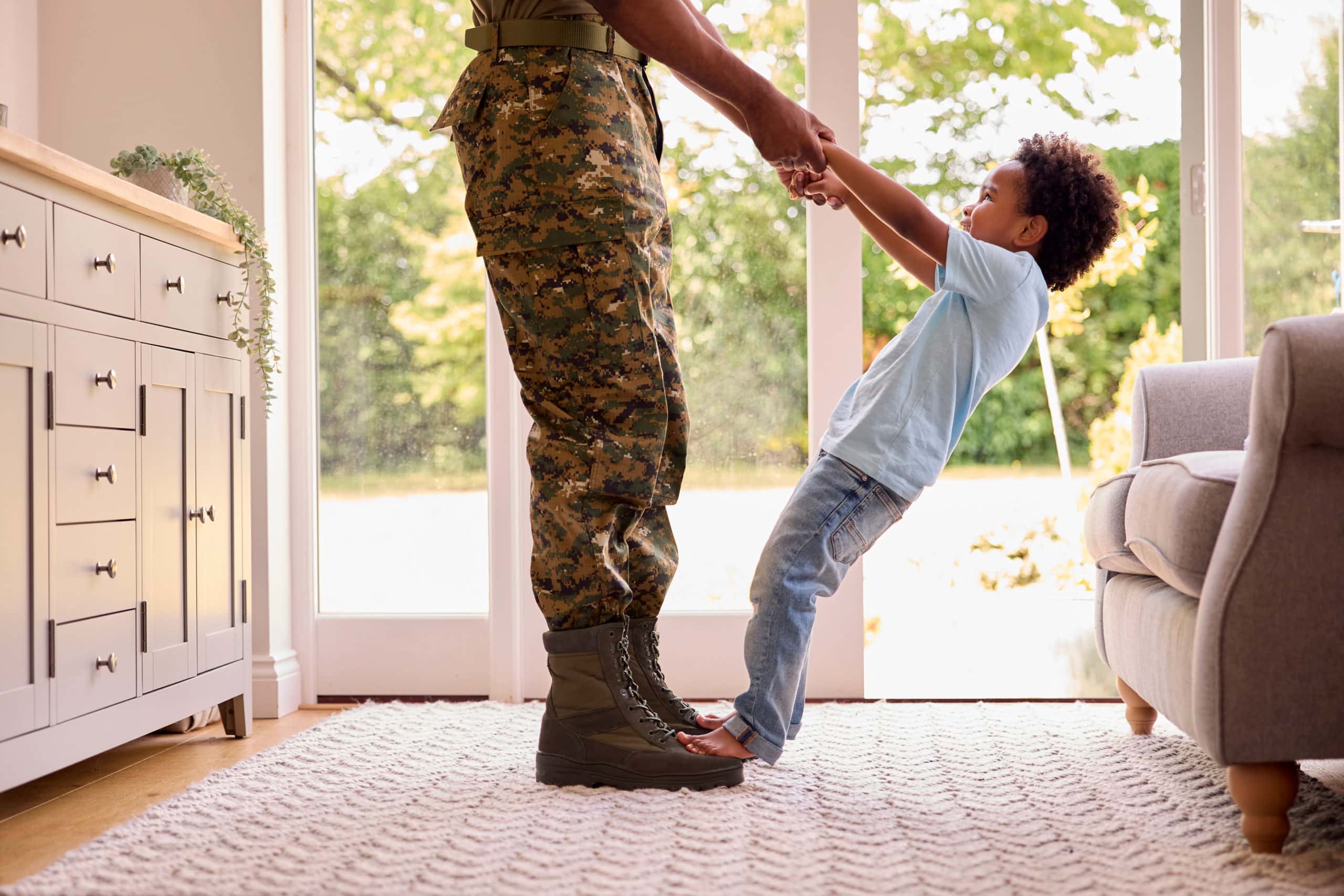 Close Up Of Loving Army Father In Uniform Home On Leave With Son