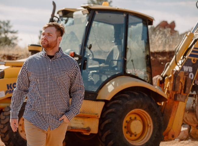 Man standing beside construction equipment at work