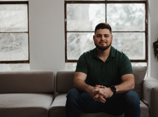 Veteran alumnus seated indoors after receiving career support