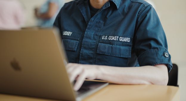 Coast Guard service member using a laptop during career transition